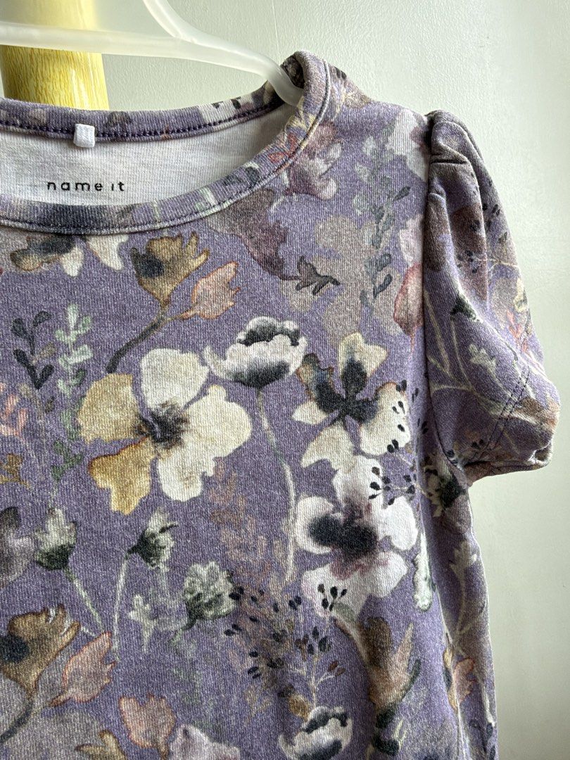 Name It Purple Floral Peplum Top (Category: Babies & Kids Fashion) located in Quezon City. Submitted by warmrabbit_414908 (Listing ID 1465594532, Image 1). Description: - Brand: Name It - Color: Dusty purple with all-over floral print - Size: Girls - Features: Short puff sleeves and cute ruffled peplum hem - Material: Soft cotton blend - Condition: Excellent, no stains or tears spotted - Perfect for everyday wear.
