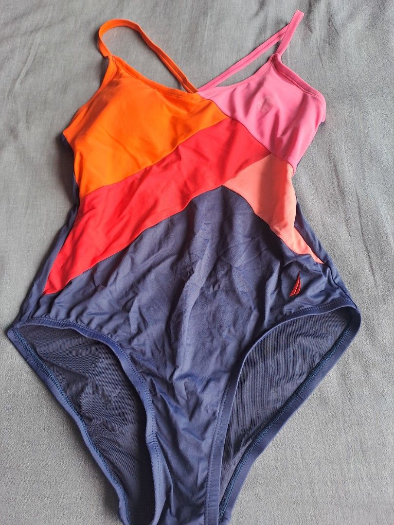 Nautica swimsuit (Category: Bikinis & Swimsuits) located in Manila. Submitted by joanbalde39643 (Listing ID 1465625896, Image 1). Description: This image shows the fabric care and content tags of a dark blue Nautica swimsuit with an orange accent piece. The clothing tag lists the following details about the item: Size: Medium.