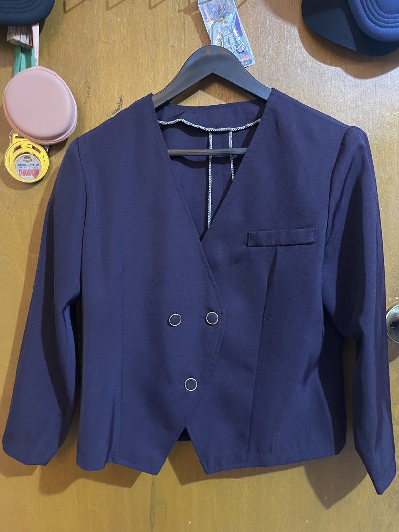 Navy Blue Buttoned Blazer Jacket (Category: Coats, Jackets and Outerwear) located in Pasay City. Submitted by etcunlimited0 (Listing ID 1465687511, Image 1). Description: - Color: Dark navy blue - Style: Collarless V-neck with asymmetrical button front - Details: Gold-rimmed buttons and one small right chest pocket - Fit: Long sleeves with clean stitched seams - Versatility: Perfect layering piece for casual tops or workwear.