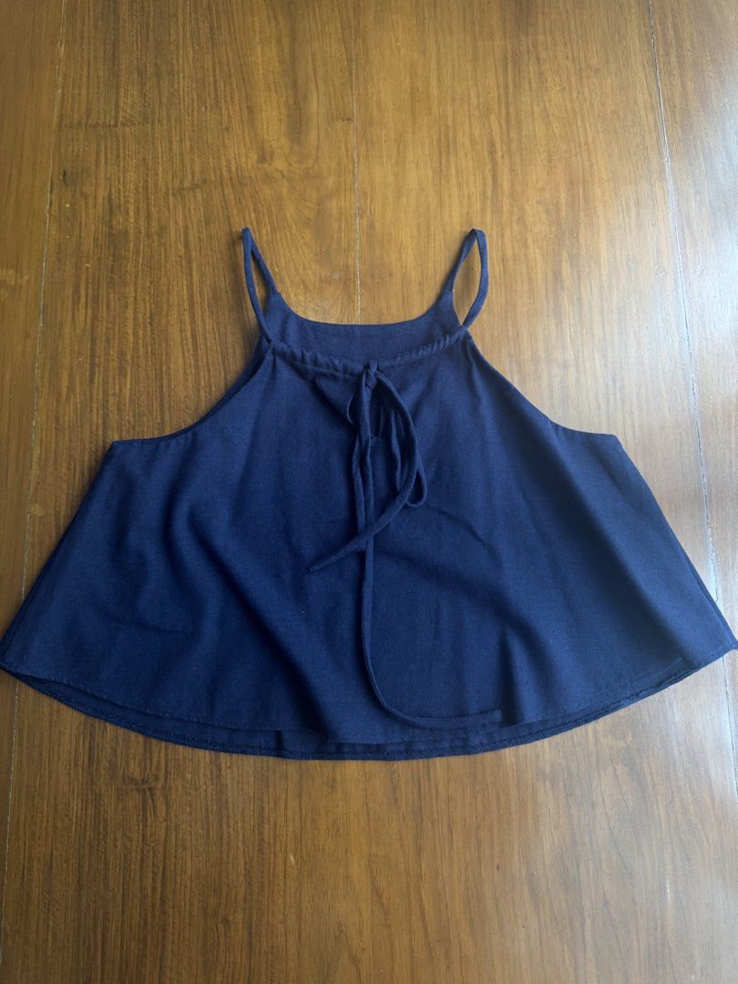 Navy Blue Halter Neck Tank Top with Tie Back (Category: Sleeveless) located in Pasig City. Submitted by kutleyn (Listing ID 1465652344, Image 2). Description: - Color: Navy blue - Style: Halter neck tank top with thin spaghetti straps - Fit: Flowy, flared silhouette - Details: Adjustable back tie closure, soft knit fabric, visible stitching on curved hem - Perfect for: Easy summer styling with shorts or skirts.