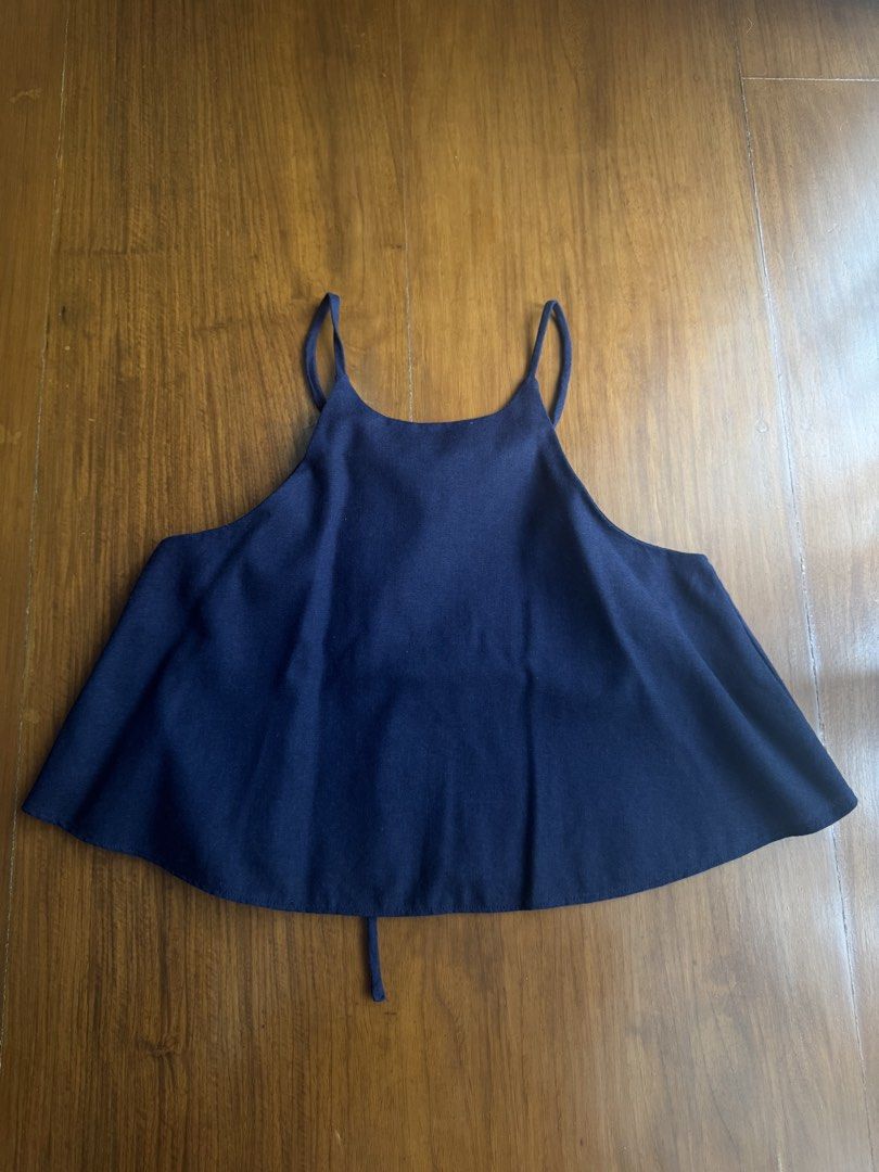 Navy Blue Halter Neck Tank Top with Tie Back (Category: Sleeveless) located in Pasig City. Submitted by kutleyn (Listing ID 1465652344, Image 1). Description: - Color: Navy blue - Style: Halter neck tank top with thin spaghetti straps - Fit: Flowy, flared silhouette - Details: Adjustable back tie closure, soft knit fabric, visible stitching on curved hem - Perfect for: Easy summer styling with shorts or skirts.