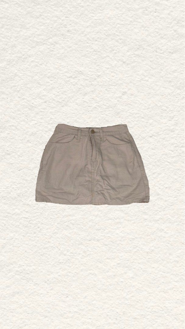 Neutral Beige Denim Mini Skirt (Category: Skirts) located in Quezon City. Submitted by zealhorse_a9f3c3 (Listing ID 1465619466, Image 1). Description: - Color: Versatile neutral beige - Material: Sturdy, durable cotton - Design: Front button closure, belt loops, and classic pocket styling - Fit: Short cut, ideal for casual wear - Condition: Minimal wear, well-maintained.