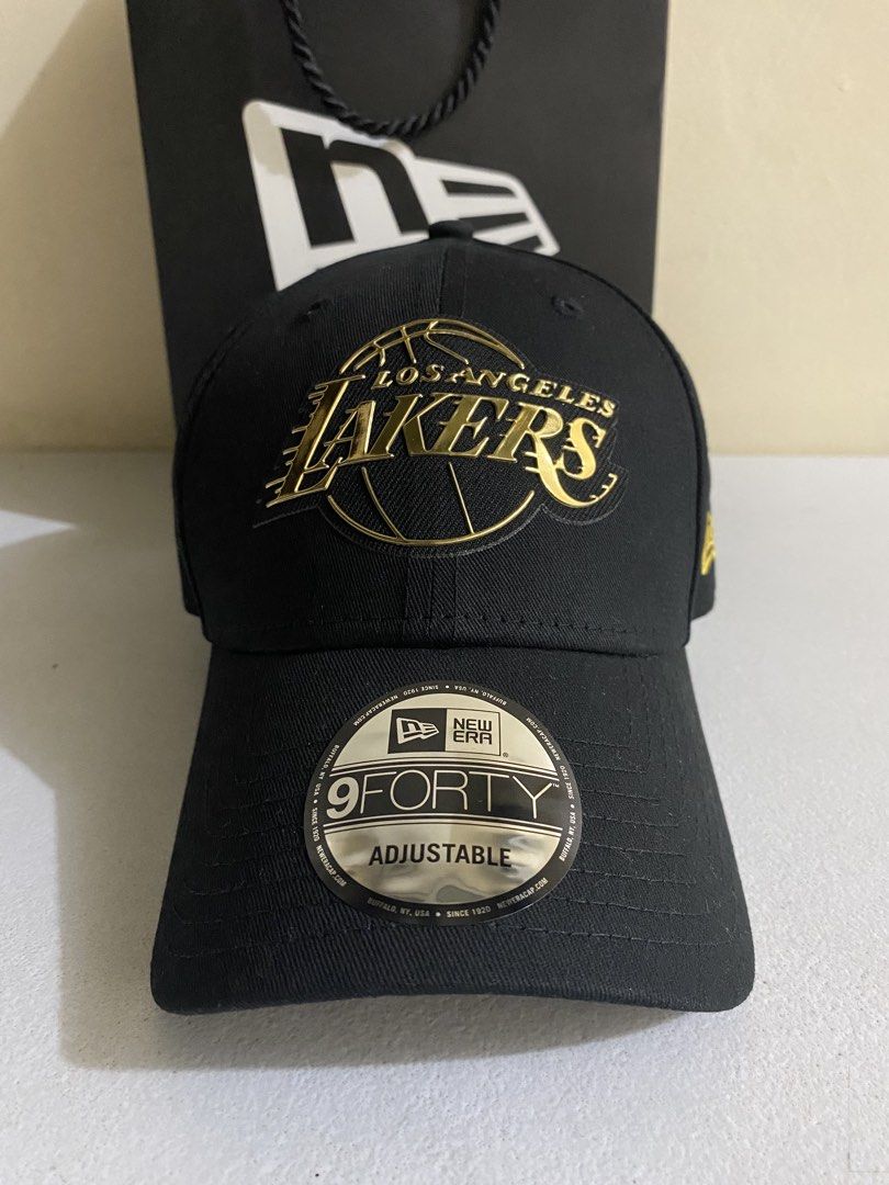 New Era Los Angeles Lakers 9FORTY Adjustable Cap 1k ( Decluttering ) (Category: Caps & Hats) located in Quezon City. Submitted by joelds (Listing ID 1465587607, Image 1). Description: - Team: Los Angeles Lakers - Color: Black with metallic gold embroidery - Details: Classic side flag logo, adjustable strap at the back.
