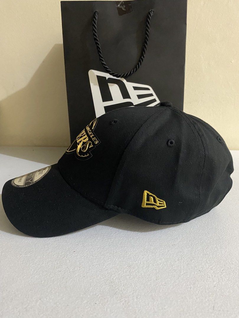New Era Los Angeles Lakers 9FORTY Adjustable Cap 1k ( Decluttering ) (Category: Caps & Hats) located in Quezon City. Submitted by joelds (Listing ID 1465587607, Image 2). Description: - Team: Los Angeles Lakers - Color: Black with metallic gold embroidery - Details: Classic side flag logo, adjustable strap at the back.