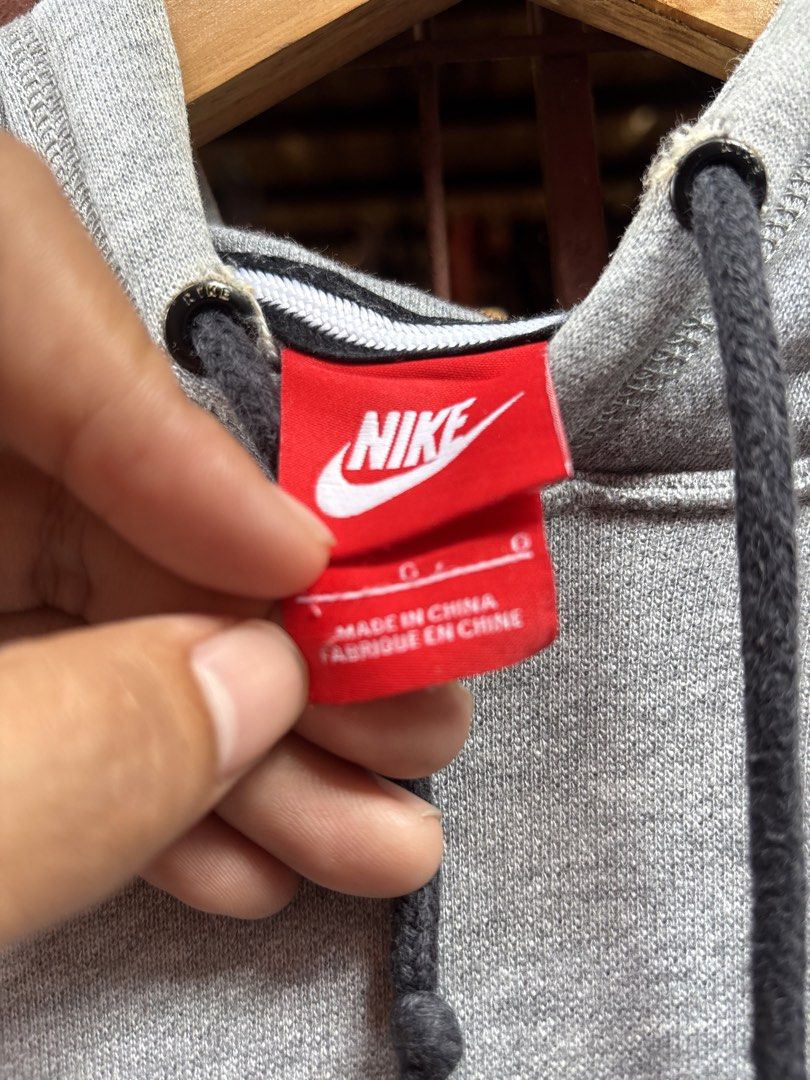 Nike Grey Logo Pullover Hoodie Size L (Category: Hoodies) located in Manila. Submitted by thriftkibs (Listing ID 1465657254, Image 2). Description: - Brand: Nike - Style: Hoodie with front kangaroo pocket and black adjustable drawstrings - Design: Large white polka-dot patterned Nike logo across the chest - Color: Grey - Size: Large (Standard fit) - Material: 100% cotton body and hood lining - Condition: Comfortably soft and great for everyday we