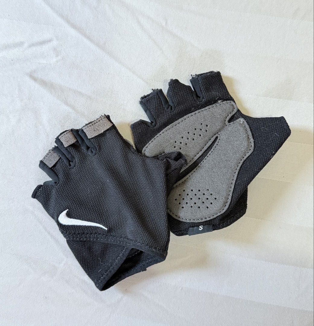 Nike Gym Gloves (Category: Gloves) located in Paranaque City. Submitted by declutternsell.729 (Listing ID 1465708337, Image 1). Description: - Brand: Nike - Item: Fingerless Gloves - Color: Black with white swoosh - Size: Small - Palms: Grey padded with ventilation holes for grip and comfort - Material: Polyester, polyurethane, nylon, and spandex blend - Ideal for: Gym sessions, weightlifting, and cycling SIZE: small.