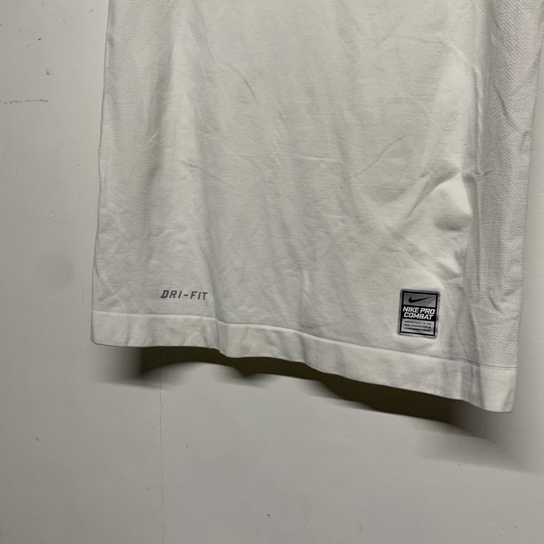 Nike Pro Combat Dri-Fit White Compression Shirt Size M (Category: Activewear) located in Manila. Submitted by grapplers.gallery (Listing ID 1465743243, Image 3). Description: - Brand: Nike Pro Combat - Size: M - Color: White - Fit: Compression / Short sleeves / V-neck - Technology: Dri-Fit moisture-wicking - Design: Textured front Swoosh and Pro Combat hem patch - Ventilation: Seamless knit with back and side zones - Origin: Made in Sri Lanka - C