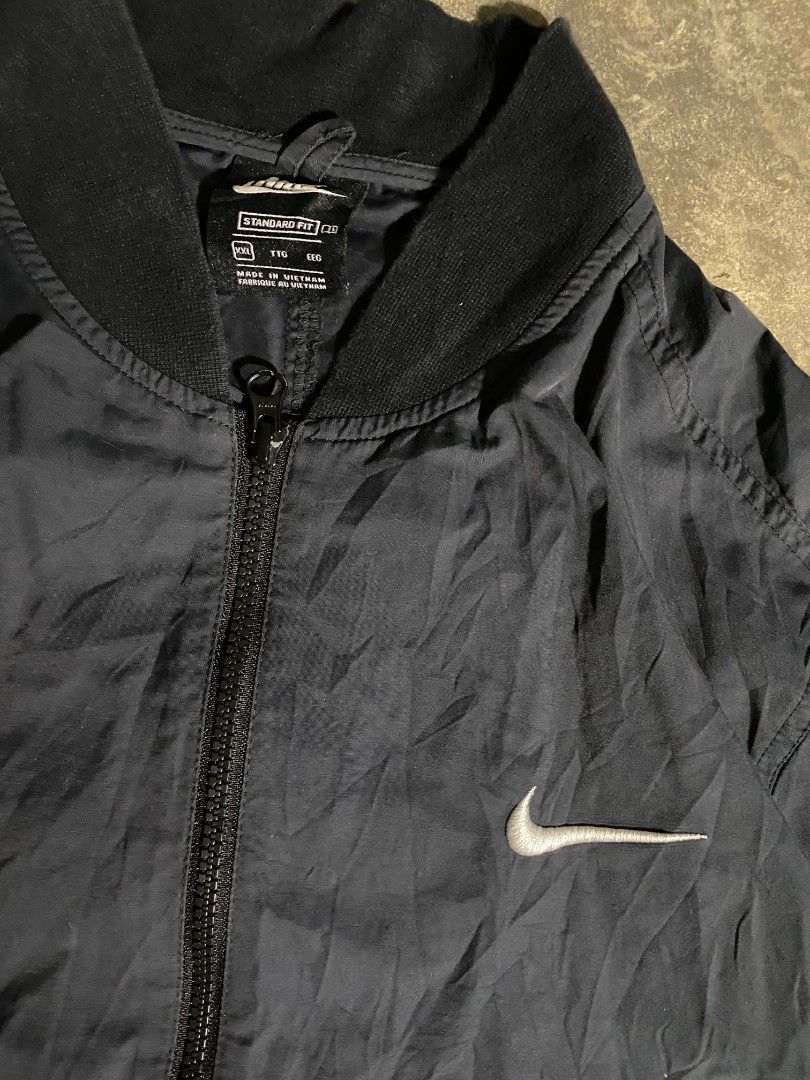 Nike Swoosh Full Zip Bomber Jacket Black XXL (Category: Coats, Jackets and Outerwear) located in Bacolod City. Submitted by richjohn.958 (Listing ID 1465719607, Image 2). Description: - Brand: Nike - Style: Bomber Jacket - Size: XXL (Standard Fit) - Color: Black with white accents - Details: Full front zip, ribbed collar and hem - Branding: Embroidered chest Swoosh, bold sleeve lettering, and large back Swoosh graphic with text - Origin: Made in 