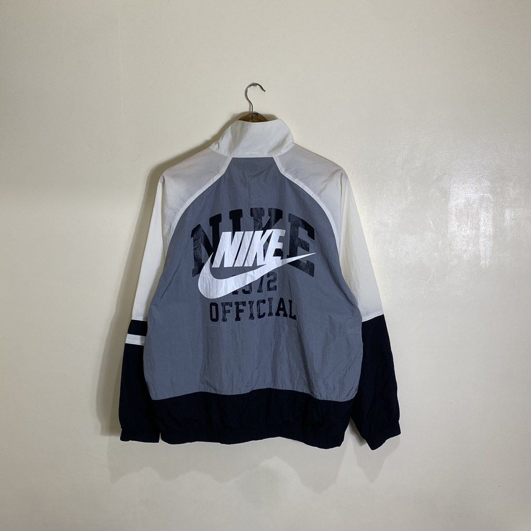 Nike Windbreaker Jacket White Grey Black Size L (Category: Coats, Jackets and Outerwear) located in Cebu City. Submitted by theloose.thread (Listing ID 1465754181, Image 2). Description: - Brand: Nike - Style: Full-zip colorblock windbreaker (White, Grey, Black) - Size: Large (Made in China) - Details: Large Nike back graphic, embroidered swoosh on chest, high collar - Condition: Clean, lightweight material perfect for breezy weather.
