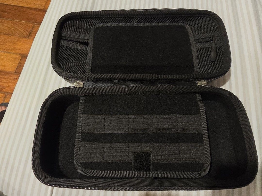 Nintendo Switch 1 V1 Carry Case (Category: Cases & Covers) located in Baguio. Submitted by joccsells (Listing ID 1465619639, Image 3). Description: for Nintendo Switch V1 - Color: Dark grey textured fabric - Hard shell exterior with soft black interior lining to prevent scratches - Built-in divider flap with multiple elastic game card slots - Mesh zipper pocket inside the top lid for cables and small accessories - Secure dual zipper closure for s