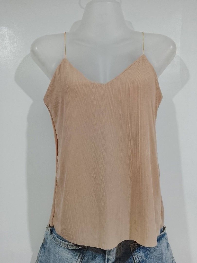 Nude spaghetti strap camisole top with pink straps (Category: Sleeveless) located in Paranaque City. Submitted by beautiful_clozet (Listing ID 1465663302, Image 1). Description: - Color: Nude - Design: V-neckline with chic thin gold spaghetti straps - Texture: Smooth, lightweight fabric with vertical pleating throughout - Fit: Relaxed body fit, easy to tuck into jeans or shorts - Style Tip: Pairs perfectly with denim for a casual yet elevated loo