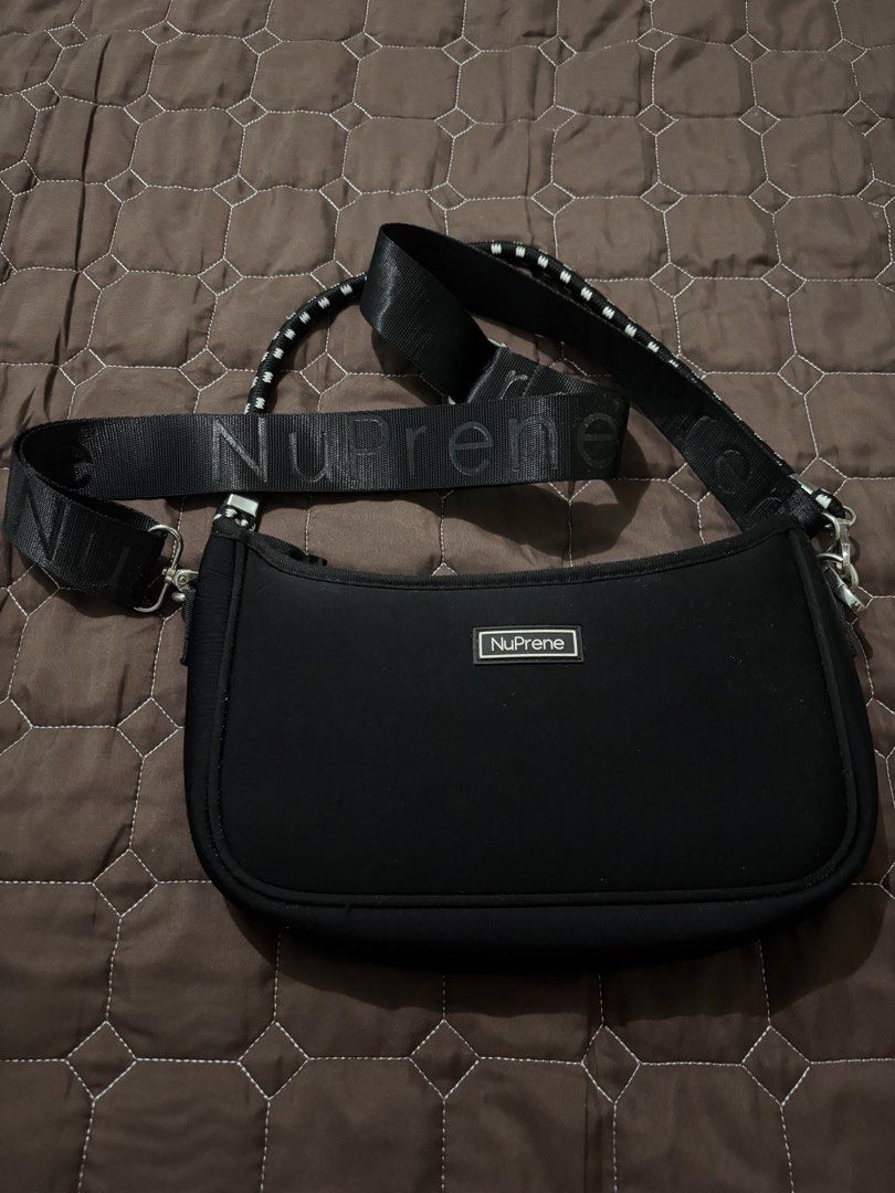 NuPrene Black Shoulder Bag with Branded Strap (Category: Shoulder Bags) located in Binan City. Submitted by fashion_claims (Listing ID 1465750817, Image 1). Description: - Brand: NuPrene - Color: Classic black - Material: Durable and lightweight neoprene - Strap: Thick, adjustable strap with bold NuPrene branding - Hardware: Silver-tone clips on both sides - Closure: Secure top zipper - Details: Front rectangular brand logo patch and clean black 