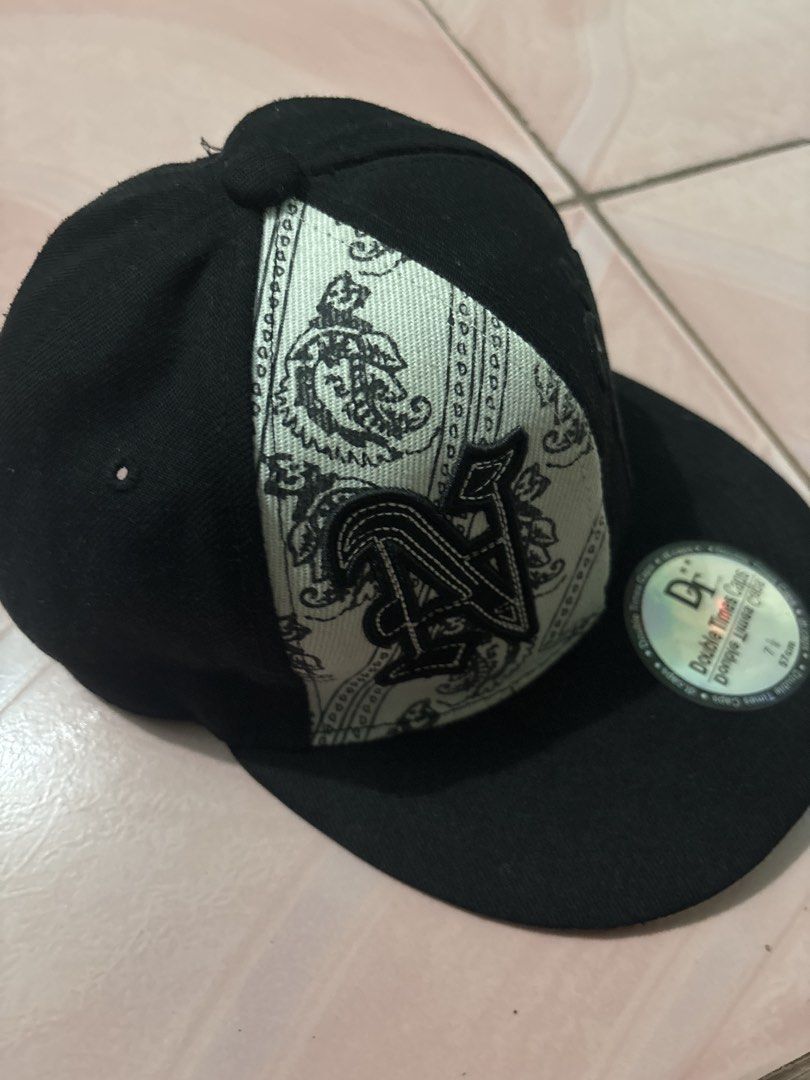 NYC Caps Black and White Snapback Hat Size 7 1/8 (Category: Caps & Hats) located in Binan City. Submitted by fashion_claims (Listing ID 1465582997, Image 3). Description: - Brand: Double Times Caps - Style: Snapback hat with unique split design (Solid black & white paisley bandana pattern) - Details: Embroidered old English front graphics and New York Yankees logo on the back - Brim: Flat brim with original holographic sticker - Size: 7 1/8 (57 c