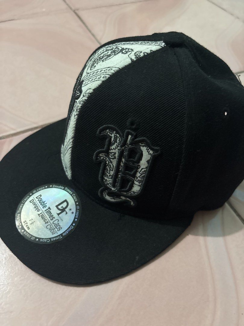 NYC Caps Black and White Snapback Hat Size 7 1/8 (Category: Caps & Hats) located in Binan City. Submitted by fashion_claims (Listing ID 1465582997, Image 2). Description: - Brand: Double Times Caps - Style: Snapback hat with unique split design (Solid black & white paisley bandana pattern) - Details: Embroidered old English front graphics and New York Yankees logo on the back - Brim: Flat brim with original holographic sticker - Size: 7 1/8 (57 c