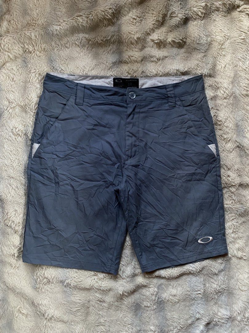 Oakley Gray Athletic Shorts (Category: Shorts) located in Andop. Submitted by safewater-895a (Listing ID 1465677313, Image 1). Description: - Brand: Oakley - Color: Gray - Closure: Button closure with belt loops - Logo: Embroidered ellipse logo on the left leg - Pockets: Two back welt pockets with white accent trim - Details: Oakley brand tag on rear waistband, clean stitching - Condition: Excellent, lightweight and durable for outdoor or casual 