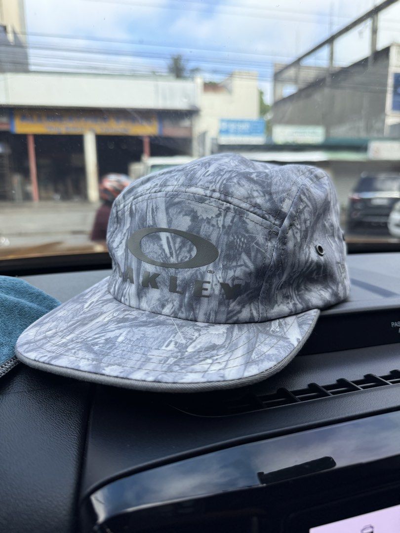 oakley hat (Category: Caps & Hats) located in Santiago. Submitted by immikehell (Listing ID 1465579195, Image 1). Description: The item in the selected region is an Oakley x Jeff Staple Collaboration 5-Panel Tree Camo Cap. This rare collector's piece is a 5-panel camper style hat. It features a distinctive grey, white, and silver-toned woodland/tree camouflage pattern throughout. The front panel is decorated with a large tonal grey print that sea