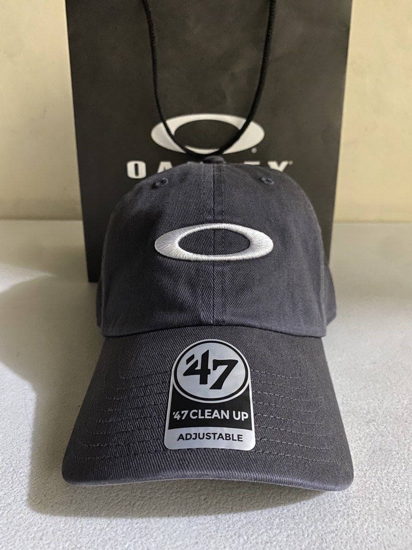 Oakley x '47 Clean Up Adjustable Hat Charcoal Grey 1k ( Decluttering ) (Category: Caps & Hats) located in Quezon City. Submitted by joelds (Listing ID 1465637732, Image 1). Description: - Brand: Oakley x '47 Clean Up collection - Color: Charcoal grey - Design: Embroidered iconic oval ellipse logo on front, '47 branding on side - Fit: Adjustable strapback closure - Brim: Curved brim with original sticker still attached - Condition: Excellent, clea