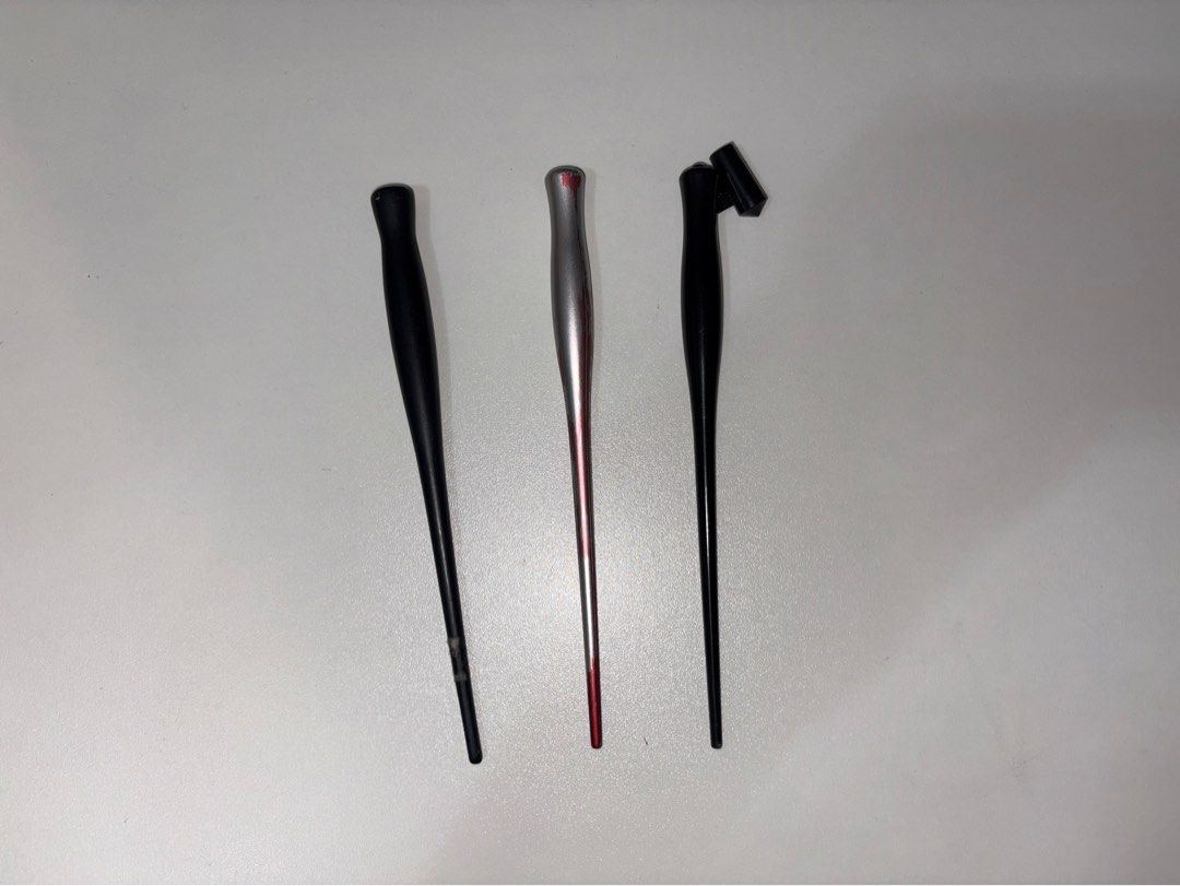 Oblique and straight calligraphy pen holders set (Category: Stationery & School Supplies) located in Quezon City. Submitted by vvelcometomyshop (Listing ID 1465755117, Image 1). Description: - Bundle of 3 calligraphy pen holders, perfect for beginners and lettering hobbyists - Black straight holder with minor wear near the tip - Silver and red metallic finish holder with visible paint chipping - Black oblique holder featuring an adjustable flange