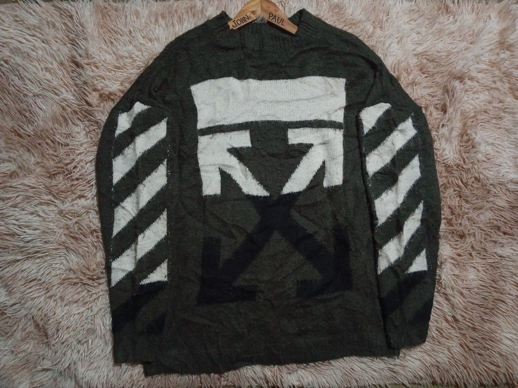 Off-White c/o Virgil Abloh Green Knit Sweater (Category: Coats, Jackets and Outerwear) located in Boston. Submitted by johnpaulvi30029 (Listing ID 1465692631, Image 1). Description: - Brand: Off-White c/o Virgil Abloh - Color: Dark green with signature white graphics - Design: Large back arrow graphic and diagonal sleeve stripes - Details: Classic ribbed collar, cuffs, and hem with 2013 copyright neck label - Fit & Material: Relaxed fit, thick kn