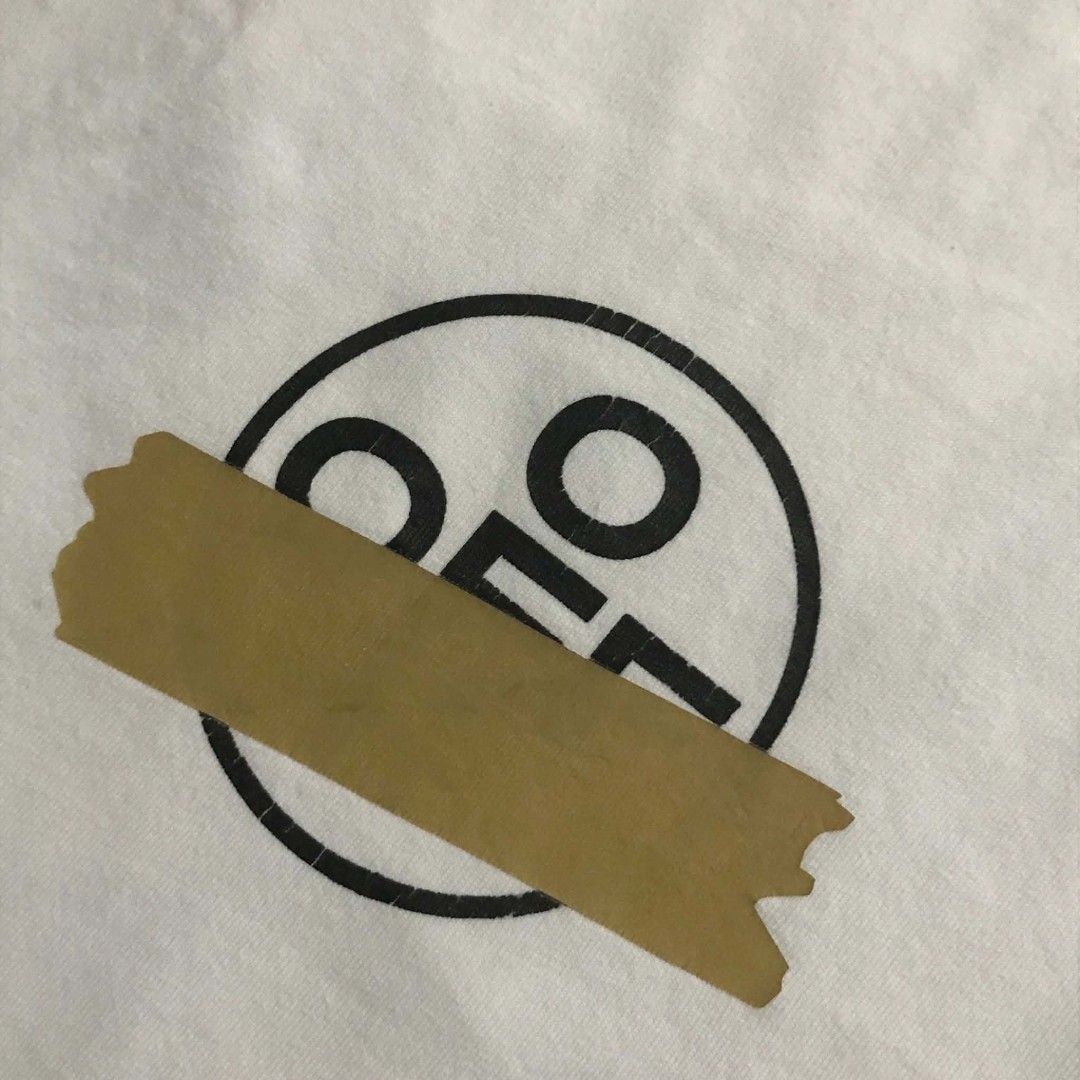 Off-White Tape Arrows White Tee (Category: Shirts) located in Manila. Submitted by its_d4ve (Listing ID 1465687360, Image 2). Description: White short sleeve tee from Off-White c/o Virgil Abloh. Iconic tape arrows graphic printed on the back and circular logo hit on the chest. "MAIN LABEL" neck tag with 2013 copyright info and standard wash care tag included. Soft cotton fabric, relaxed streetwear fit..