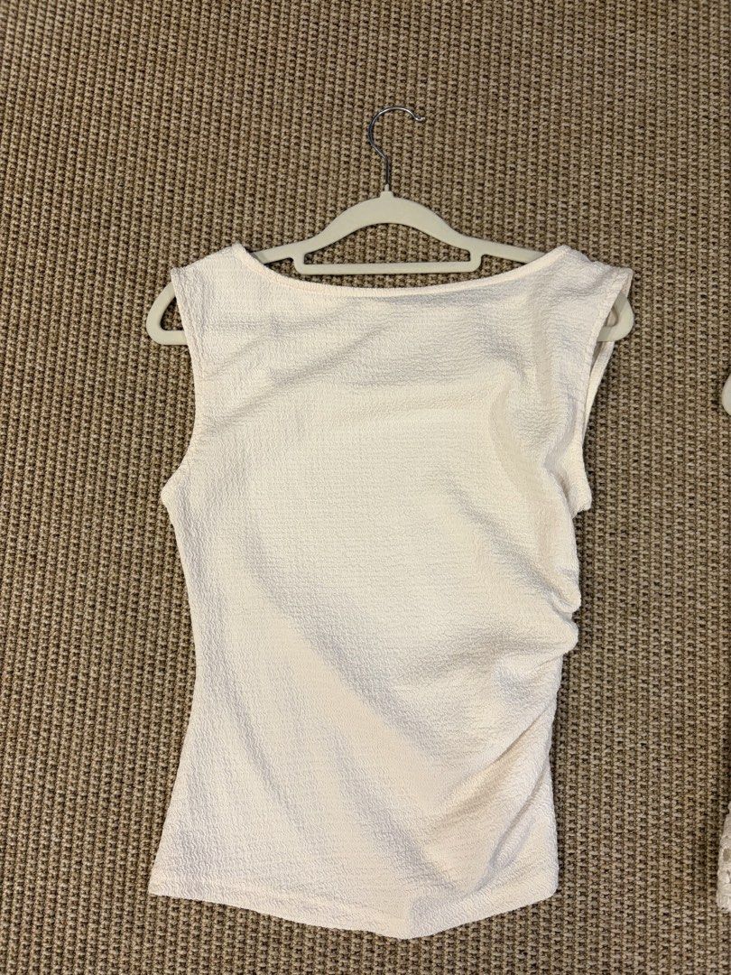 Off-white textured boat neck sleeveless top (Category: Sleeveless) located in Pasig City. Submitted by bfa1017 (Listing ID 1465655755, Image 1). Description: - Color: Off-white - Style: Sleeveless top with boat neckline - Details: Textured crinkle pattern and gathered side for a fitted look - Fabric: Lightweight and breathable .