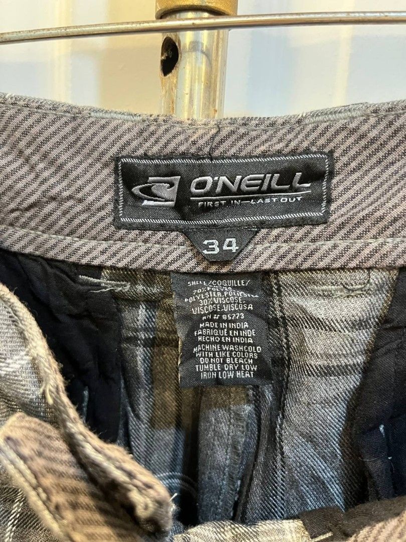 O'Neill Grey Plaid Shorts Size 34 (Category: Shorts) located in Quezon City. Submitted by chicberry (Listing ID 1465719205, Image 3). Description: - Brand: O'Neill - Style: Plaid shorts (Grey, black, and white tones) - Size: Men's 34 waist - Material: Comfortable cotton and viscose blend - Features: Button closure, belt loops, and back pockets with button flap closure - Details: Embroidered logo text above the right back pocket - Care: Machine wa