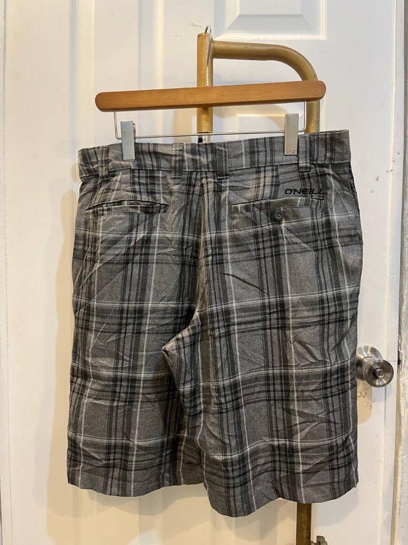 O'Neill Grey Plaid Shorts Size 34 (Category: Shorts) located in Quezon City. Submitted by chicberry (Listing ID 1465719205, Image 2). Description: - Brand: O'Neill - Style: Plaid shorts (Grey, black, and white tones) - Size: Men's 34 waist - Material: Comfortable cotton and viscose blend - Features: Button closure, belt loops, and back pockets with button flap closure - Details: Embroidered logo text above the right back pocket - Care: Machine wa
