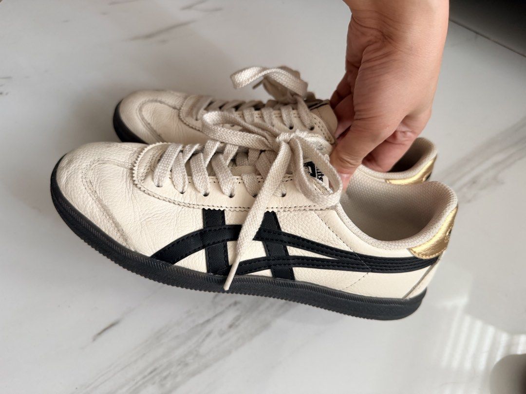 Onitsuka Tiger Tokuten Sneakers (Category: Sneakers) located in Quezon City. Submitted by hjane26 (Listing ID 1465636476, Image 2). Description: - Color/Material: White leather with black side stripes and metallic gold heel tab - Style: Classic low-top sneakers with flat white laces and black rubber soles - Details: Branded insoles - Condition: Gently worn, light creasing on toe boxes - RFS: Decluttering closet, grab it before it's gone! - Size: 