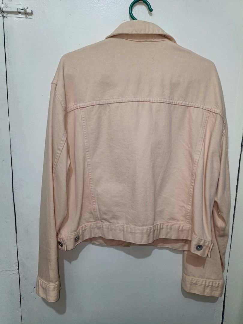 Uniqlo Peach pink denim jacket button up outerwear (Category: Coats, Jackets and Outerwear) located in Quezon City. Submitted by closeta38 (Listing ID 1465583364, Image 2). Description: - Peach pink denim jacket with a solid pastel tone - Button-up front with matching metal buttons - Two chest pockets with flaps and convenient side welt pockets - Long sleeves with adjustable buttoned cuffs - Structured collar and classic fit - Perfect layering pi
