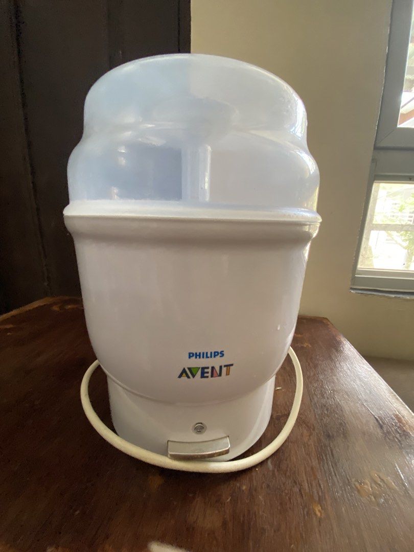 Philips Avent Electric Steam Sterilizer (Category: Breastfeeding & Bottle Feeding) located in Manila. Submitted by king_1989 (Listing ID 1465591015, Image 1). Description: - Authentic Philips Avent electric steam sterilizer in white and translucent blue - Includes main heating base, cover lid, and internal baskets with central stem - Simple one-touch operation with a single front push button - Efficiently cleans and sterilizes multiple baby bottl