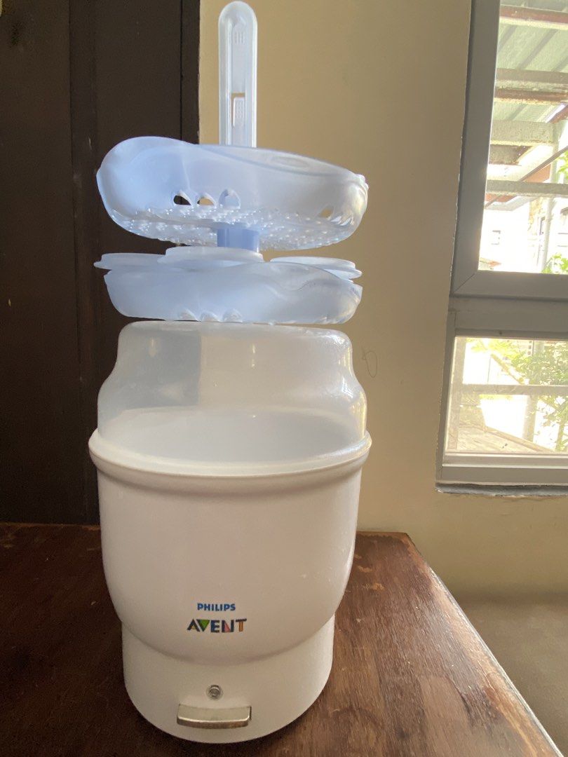 Philips Avent Electric Steam Sterilizer (Category: Breastfeeding & Bottle Feeding) located in Manila. Submitted by king_1989 (Listing ID 1465591015, Image 3). Description: - Authentic Philips Avent electric steam sterilizer in white and translucent blue - Includes main heating base, cover lid, and internal baskets with central stem - Simple one-touch operation with a single front push button - Efficiently cleans and sterilizes multiple baby bottl