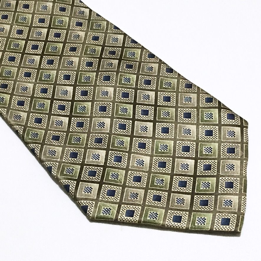 Pierre Cardin Diamond Grid Pattern Hand Made Neck Tie (Category: Ties) located in Taguig. Submitted by retrogaze (Listing ID 1465675924, Image 2). Description: This vintage 100% silk handmade necktie by Pierre Cardin features a warm beige and golden-olive base woven with a luminous satin finish. The body is decorated with an intricate geometric diamond-grid pattern. Each diamond compartment houses alternating geometric centers—either a solid navy