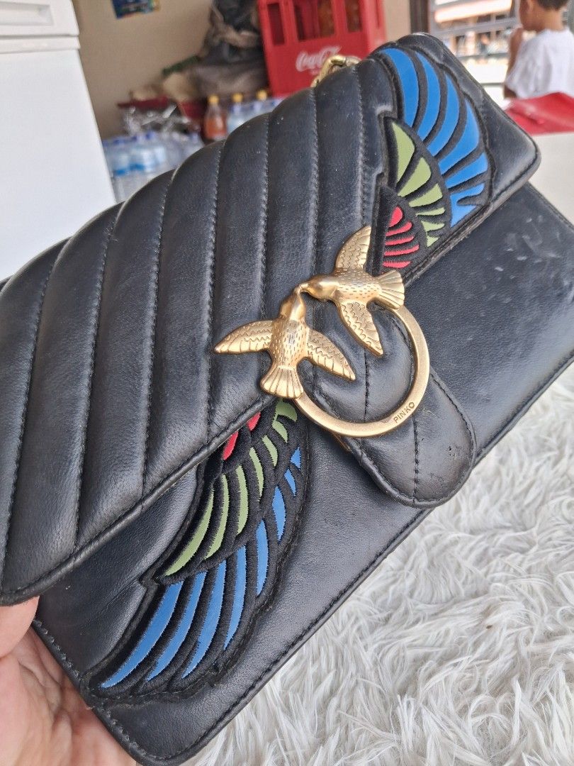 Pinko Black Leather Love Bag with Chain Strap (Category: Luxury Bags & Wallets) located in Agoncillo. Submitted by vinsoy07 (Listing ID 1465662821, Image 3). Description: - Pinko crossbody bag in black leather with chevron quilting - Features iconic gold metal Love Birds buckle on the front flap - Unique and colorful embroidered wing details on the sides - Compact dimensions: approx. 20 cm x 10 cm - Stylish chunky gold chain shoulder strap - Prac