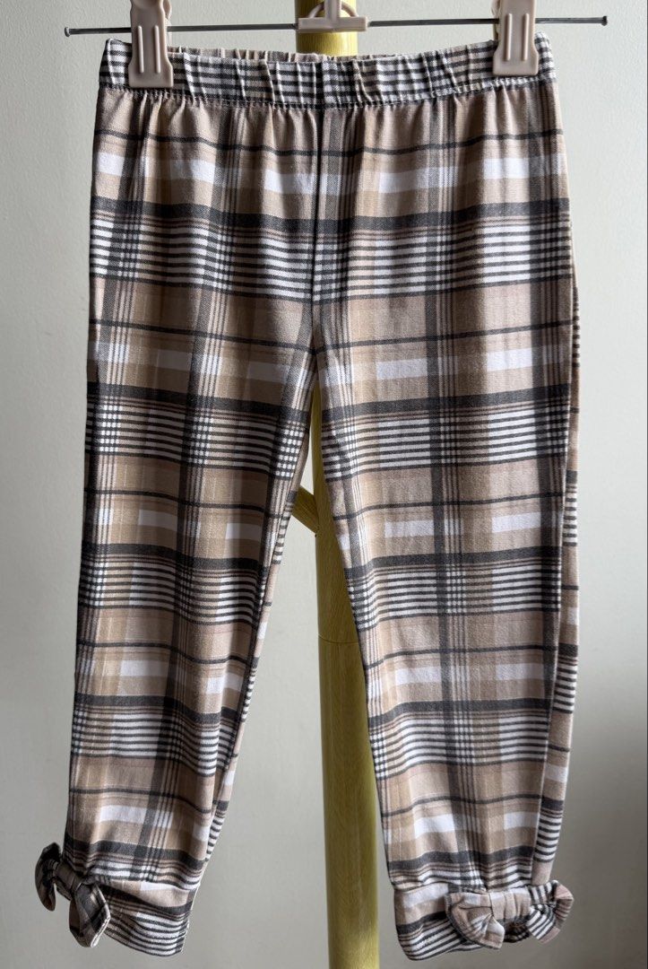 Nicole Miller Plaid Checkered Casual Pants with Hem Bows (Category: Babies & Kids Fashion) located in Quezon City. Submitted by warmrabbit_414908 (Listing ID 1465596699, Image 3). Description: - Style: Tan plaid trousers with black and white checkered lines - Fit: Easy pull-on style with a comfortable elastic waistband - Details: Cute fabric bows tied at both cuffs - Fabric: Soft and comfy for daily wear.
