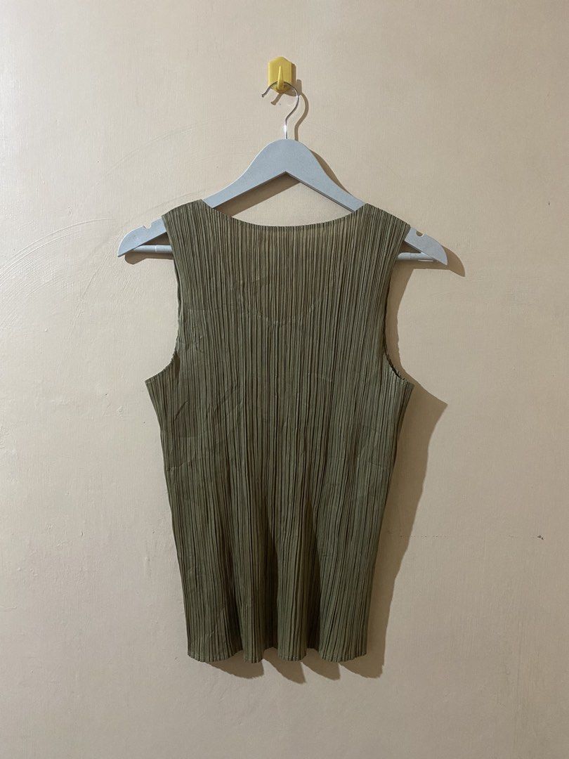 Pleats Please Issey Miyake sleeveless top (Category: Sleeveless) located in Naga. Submitted by trashfinds (Listing ID 1465593571, Image 2). Description: This garment is a pleated sleeveless top, iconic for its distinct finely crinkled texture known as plissé or garment-pleating.The color is a muted khaki or olive green, and the design is highly reminiscent of pieces from the signature Pleats Please Issey Miyake collection. This lightweight, stret