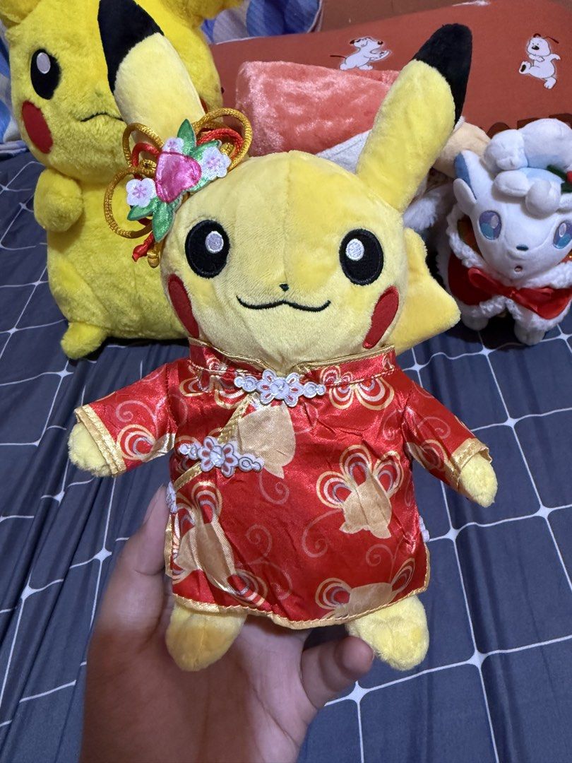 Pokemon Pikachu Lunar New Year Plush (Category: Plushies & Soft Toys) located in Ozamiz City. Submitted by clickerx (Listing ID 1465665814, Image 1). Description: - Adorable Pikachu plush in a traditional red and gold cheongsam outfit - Features a detailed floral hair accessory attached to the ear - Vibrant colors highlighted with elegant golden swirl patterns - Clean fabric, smoke-free, and well-kept collector's item - Perfect gift for Pokémon f