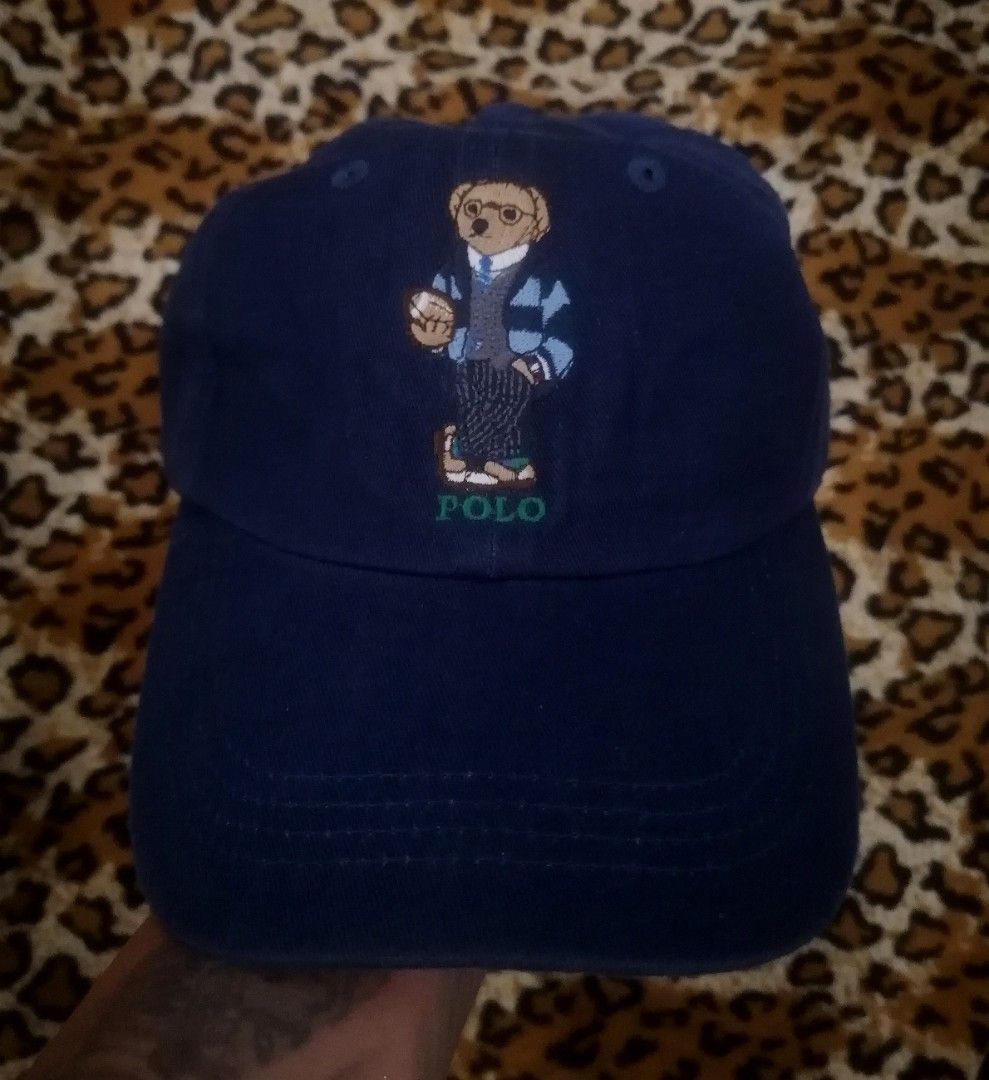 Polo Ralph Lauren Bear Navy Baseball Cap (Category: Caps & Hats) located in Cebu City. Submitted by roadthrift (Listing ID 1465702987, Image 1). Description: - Brand: Polo Ralph Lauren - Color: Navy Blue - Design: Iconic Polo Bear holding a football embroidered on front with 'POLO' lettering - Back Details: 'POLO RALPH LAUREN' embroidered across the strap area - Material: 100% cotton - Size: One size fits most (tagged 59cm), adjustable metal buck