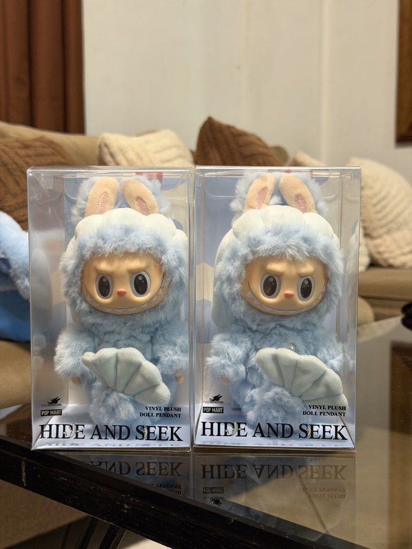 Pop Mart Labubu Hide And Seek - Merbubu (Category: Designer & Blind Box Toys) located in Manila. Submitted by jnndeclutter (Listing ID 1465722140, Image 2). Description: ₱2,500 left - minimal dents due to transport in luggage ₱2,700 right - mint condition - Item: Pop Mart Labubu Hide and Seek Vinyl Plush Doll Pendant - Design: Soft blue furry body with bunny ears, holding a fan - Condition: Brand new, unopened clear display box with original POP 