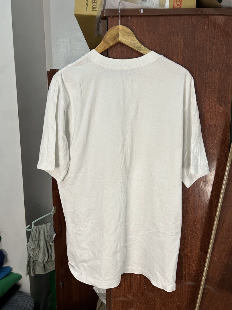 Prada White T-Shirt with Beaded Triangle Logo (Category: Shirts) located in Davao. Submitted by ruggedthrift444 (Listing ID 1465687521, Image 2). Description: - Brand: Prada - Color: White with black triangular chest patch - Details: Embellished gold-tone beads and clear crystals spelling out the brand name on the chest - Fit: Standard relaxed fit - Material: Premium cotton with ribbed collar detailing - Condition: Brand new / Excellent quality -