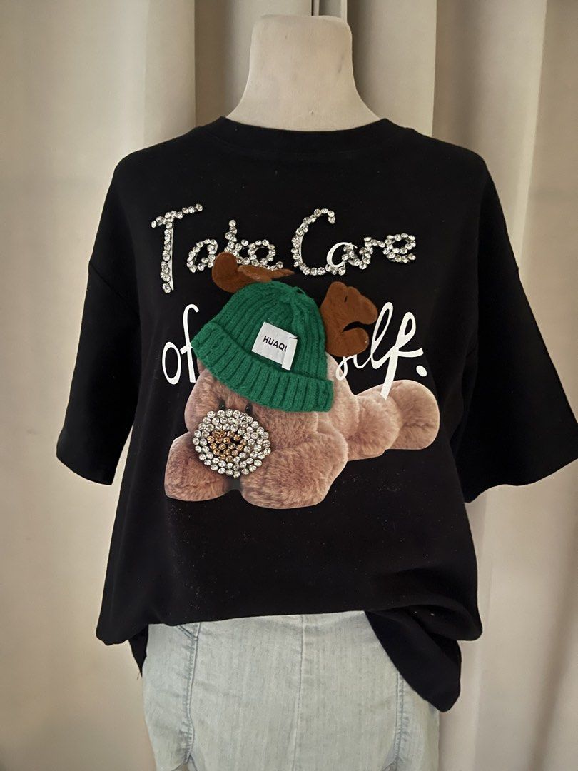 premium heavy cloth bear tee (Category: Shirts) located in Cainta. Submitted by zlove111 (Listing ID 1465758232, Image 3). Description: - Color: Black - Style: Relaxed fit, super soft short-sleeve tee - Design: Large fluffy teddy bear wearing a 3D green knit beanie with antlers - Details: Sparkling rhinestone accents on the 'Take Care of Yourself' lettering and bear's nose - Perfect for a cozy, stylish everyday look! good stretch crewneck heavy c