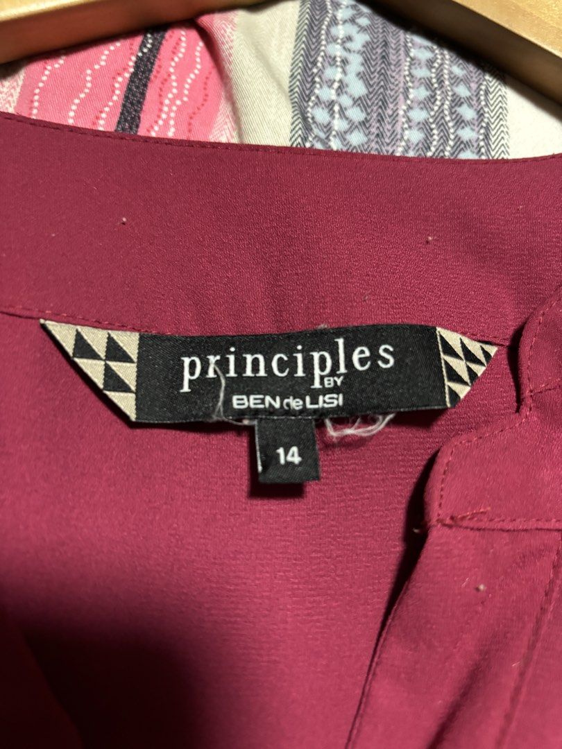 Principles by Ben de Lisi Maroon Blouse Size 14 (Category: Blouses) located in Quezon City. Submitted by declutter_incorporated (Listing ID 1465694155, Image 2). Description: - Brand/Label: Principles by Ben de Lisi - Size: 14 - Color: Maroon - Neckline: V-neck with split front placket - Sleeves: Short sleeves with gathered shoulder detail - Hem: Curved hem, slightly longer in the back - Back Details: Center inverted pleats on the back yoke - Fab