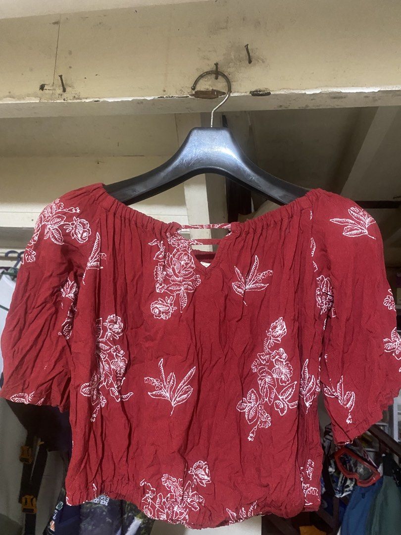 Red Off-Shoulder Floral Print Blouse (Category: Blouses) located in Nagcarlan. Submitted by fiercewater-40fb (Listing ID 1465720988, Image 1). Description: - Color & Pattern: Deep red with white floral illustrations - Design: Off-shoulder neckline with front strap detail, half sleeves - Fit: Elastic neckline and hemline for a gathered, flattering fit - Material: Lightweight and breathable fabric - Style: Ideal for casual daily outfits and easy st