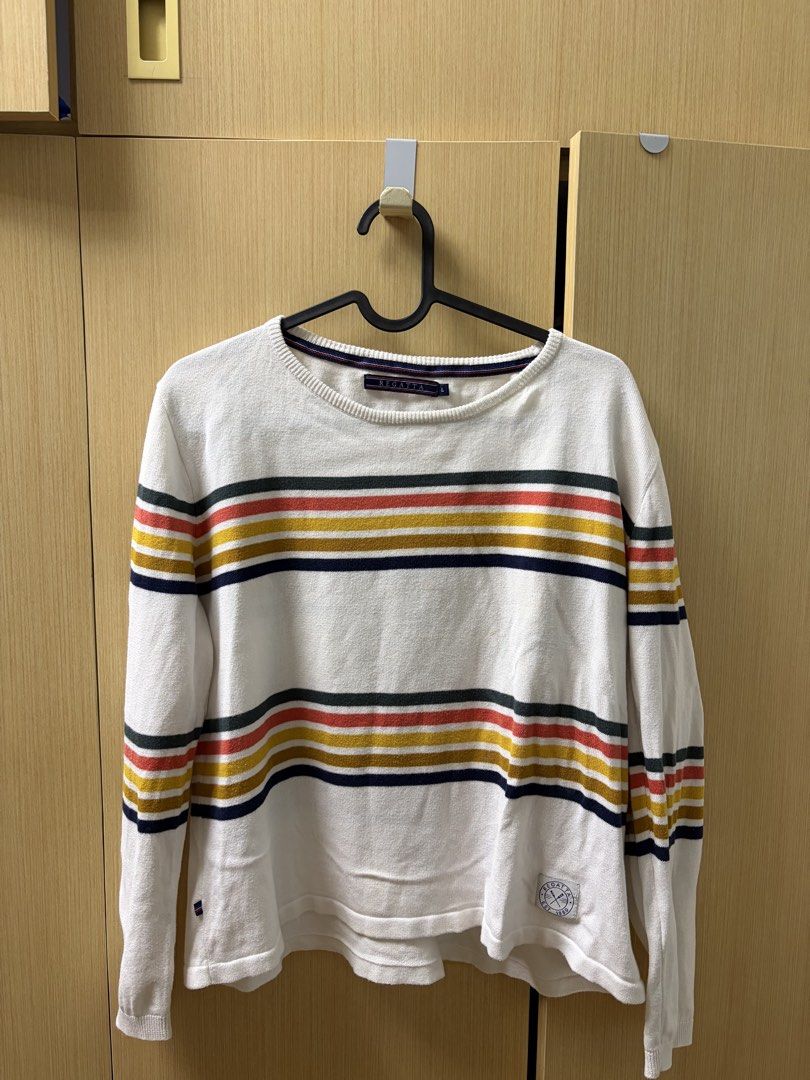 Regatta Striped Knit Sweater Size L (Category: Longsleeves) located in Makati City. Submitted by declutteringgatm (Listing ID 1465749515, Image 1). Description: - White knit sweater with dark green, red, yellow, and navy blue horizontal stripes - Features long sleeves, a classic round neckline, and a small circular patch near the bottom hem - Regular fit made from a lightweight, comfortable knit material - Size: Large - Ideal casual piece for coo
