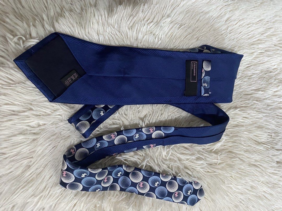 Renoma Paris Blue Patterned Tie (Category: Ties) located in Bulacan. Submitted by rich2545 (Listing ID 1465581182, Image 2). Description: - Brand: Renoma Paris - Color: Deep blue with blue, grey, white, and pink pattern - Design: Overlapping circles - Size: Standard width - Features: Blue keeper loop and branded back label - Condition: Clean and ready to wear for work or formal events.