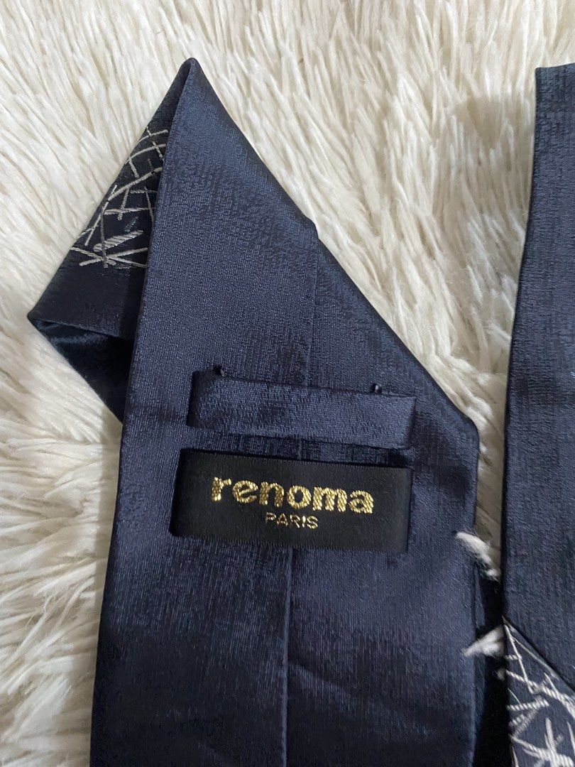 Renoma Paris Dark Blue Tie with Abstract Silver Pattern (Category: Ties) located in Bulacan. Submitted by rich2545 (Listing ID 1465581573, Image 3). Description: - Brand: Renoma Paris - Material: Premium Silk - Color/Design: Dark blue textured fabric with abstract silver and blue stick pattern - Fit: Standard width cut - Details: Includes branded loop and luxurious gold tipping cloth inside the tail - Condition: Excellent pre-loved condition - Pe