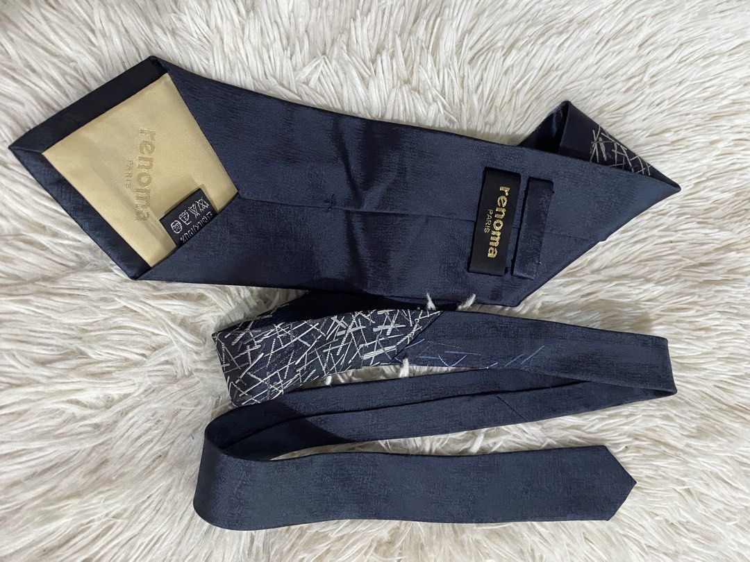Renoma Paris Dark Blue Tie with Abstract Silver Pattern (Category: Ties) located in Bulacan. Submitted by rich2545 (Listing ID 1465581573, Image 2). Description: - Brand: Renoma Paris - Material: Premium Silk - Color/Design: Dark blue textured fabric with abstract silver and blue stick pattern - Fit: Standard width cut - Details: Includes branded loop and luxurious gold tipping cloth inside the tail - Condition: Excellent pre-loved condition - Pe