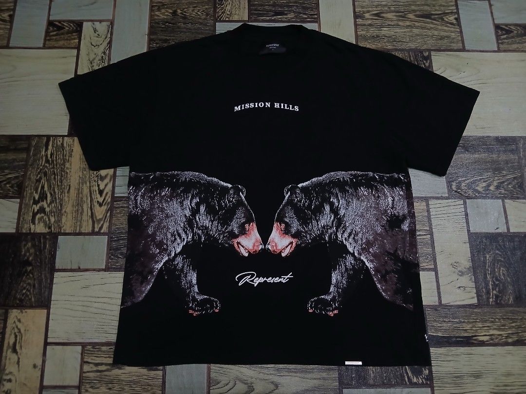 Represent Mission Hills Bear Graphic Tee Black Medium (Category: Tshirts & Polo Shirts ) located in Caloocan City. Submitted by youngmoon_51e2c6 (Listing ID 1465684122, Image 1). Description: - Brand: Represent - Color: Black with large front graphic print ('Mission Hills' & bear) - Size: Medium (with branded collar label) - Details: Woven metal tag on hem, crew neck design - Material: 100% premium cotton, Made in Portugal - Condition: 100% authe