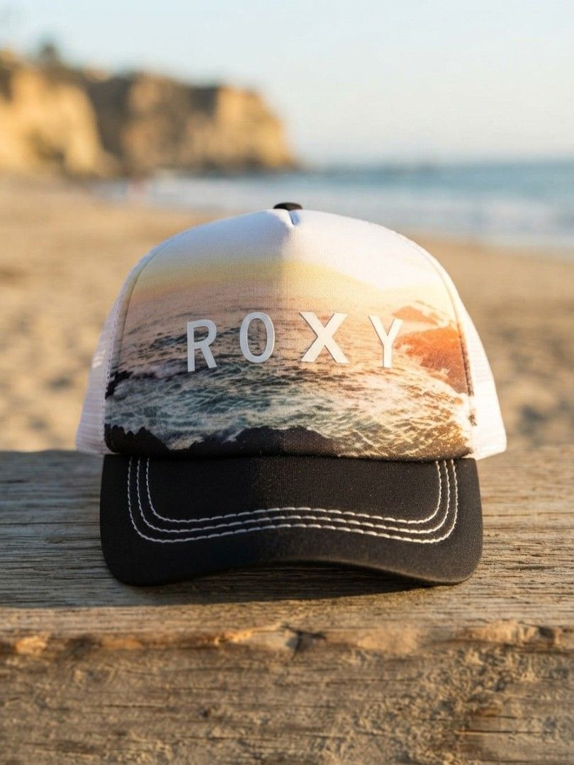 ROXY Sunset Ocean Print Trucker Hat (Category: Hats & Beanies) located in Binangonan. Submitted by yuristalin888 (Listing ID 1465583157, Image 1). Description: * **Design:** Features a scenic coastal sunset and ocean graphic front panel with bold white "ROXY" lettering. * **Structure:** Classic trucker style combining a structured printed front, breathable white mesh back panels, and a contrasting black curved brim with decorative stitching. * **