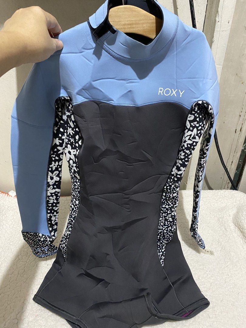 Roxy Women's Springsuit Wetsuit (Category: Rash guard) located in Manila. Submitted by resi.diaz (Listing ID 1465751371, Image 2). Description: - Brand: Roxy - Size: 4 - Design: Light blue, dark grey, and black floral pattern with purple inner lining - Features: Long sleeves, short bottoms, back zip entry, and hook-and-loop collar closure.
