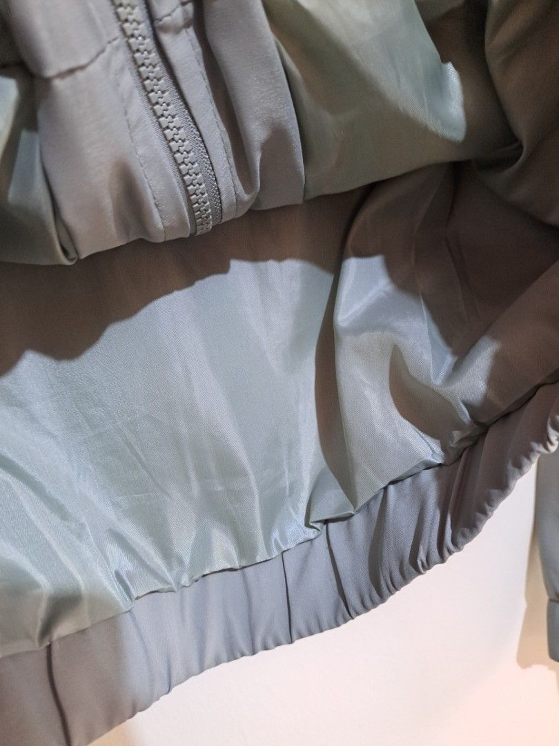 Sage Green Windbreaker Jacket (Category: Coats, Jackets and Outerwear) located in Manila. Submitted by yselles__ (Listing ID 1465606395, Image 2). Description: - Closure: Full front zipper - Features: Attached hood and two large chest utility pockets - Comfort: Elastic cuffs and hemline for a snug fit - Lining: Matching tone inside lining - Condition: Clean, solid construction, perfect for everyday casual wear.